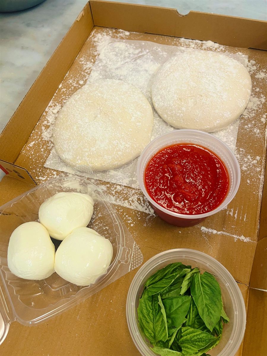 Take-home pizza kit with two dough balls, sauce, fresh mozzarella and basil